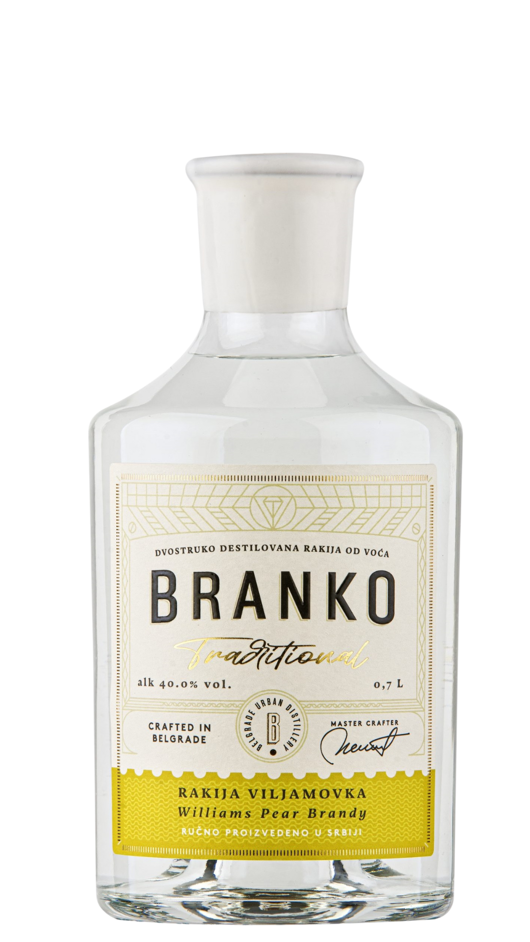 A clear glass bottle of Branko Traditional Williams Pear Brandy with a white label and yellow text, indicating the brand and flavour.